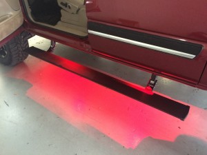 Amp research motorized running boards with red Rigid A series lights