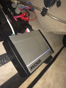 Amplifier mounted under passenger storage area
